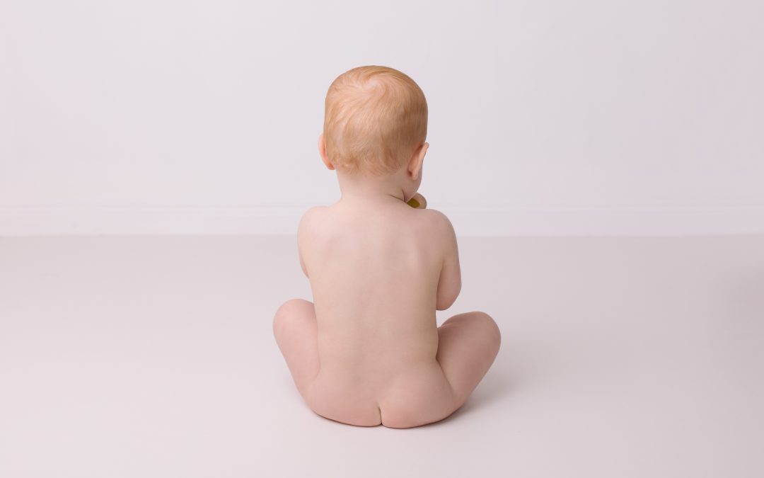 professional baby photo of baby sitting naked facing away from camera showing bare bottom., photo by Edinburgh baby photographer Beautiful Bairns Photography
