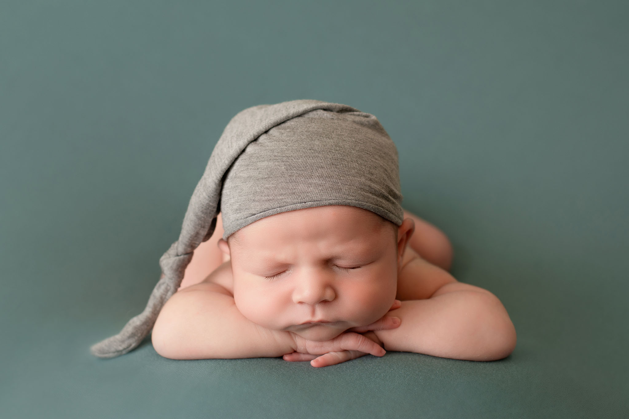 professional newborn baby photo of baby boy laid on tummy wearing grey sleepy hat on green blanket by edinburgh newborn photographer beautiful bairns photography