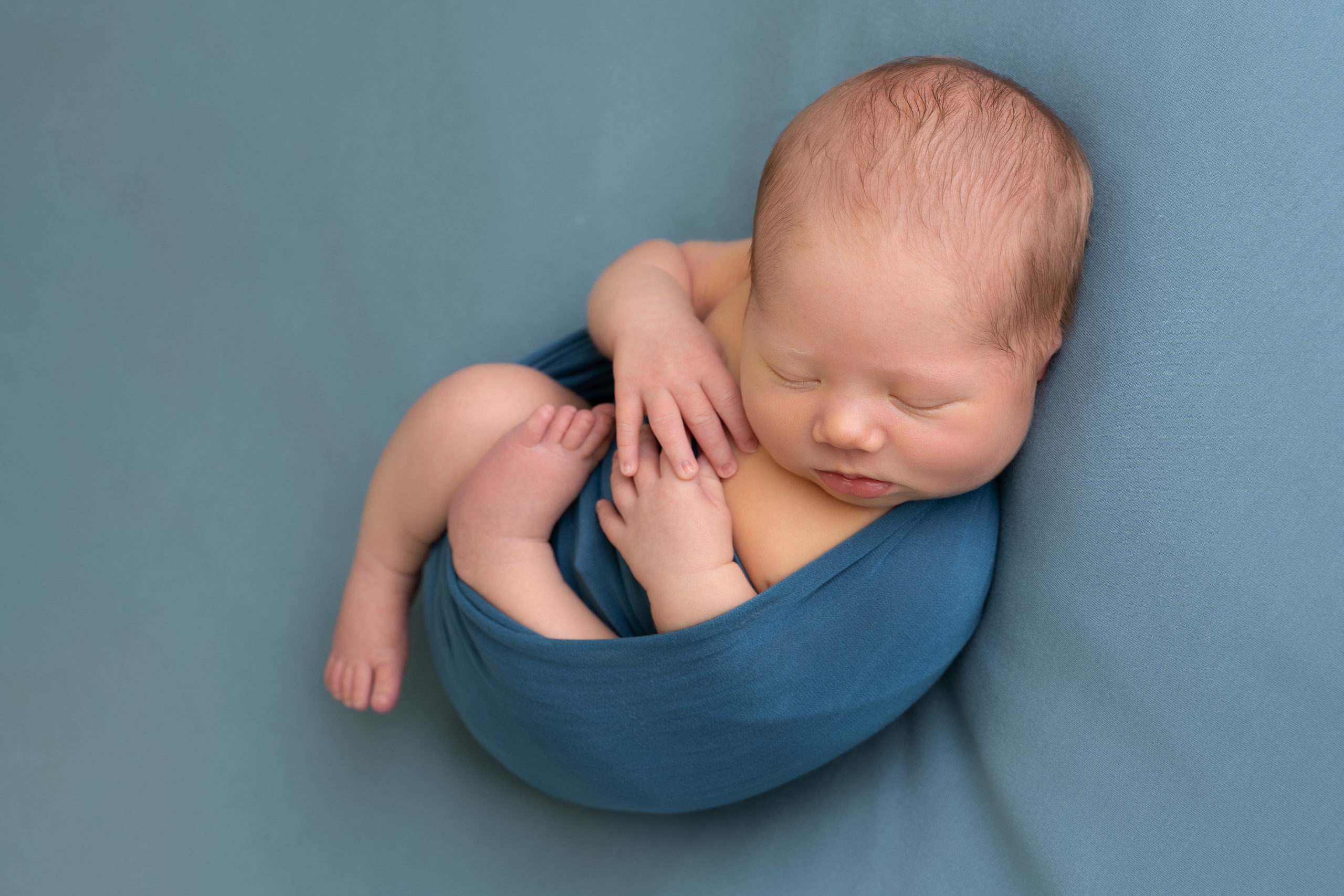 professional newborn photo of newborn baby posed on teal blanket by newborn photographer edinburgh beautiful bairns