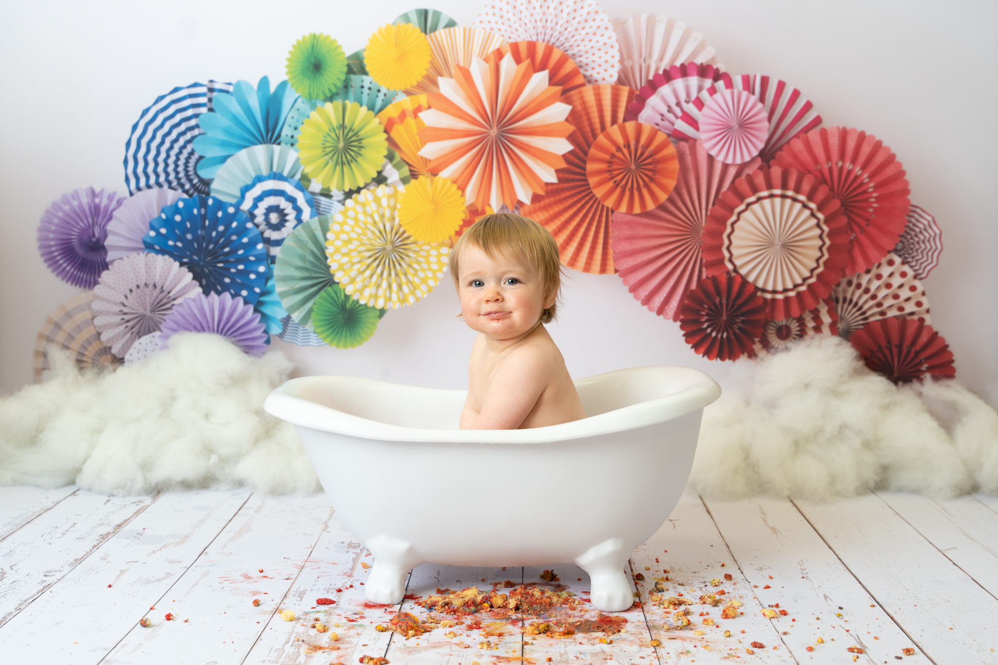 photo of a baby sitting in a rollmop bath after her cake smash photoshoot by Beautiful Bairns Photography Edinburgh
