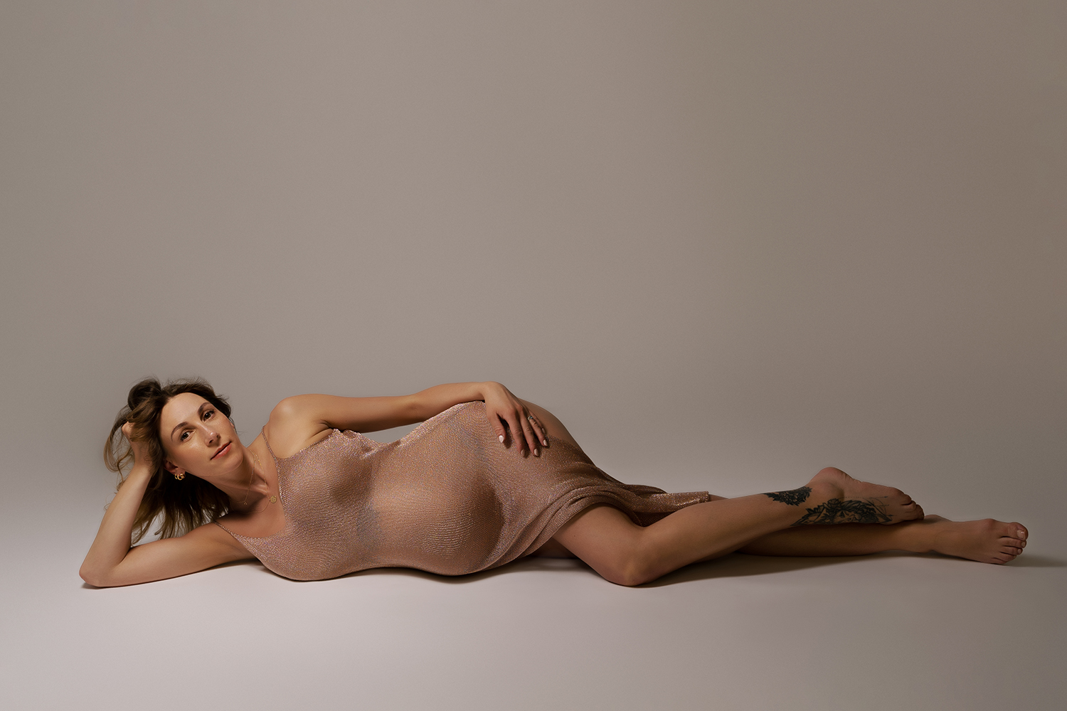 professional maternity photo of pregnant woman laying on her side