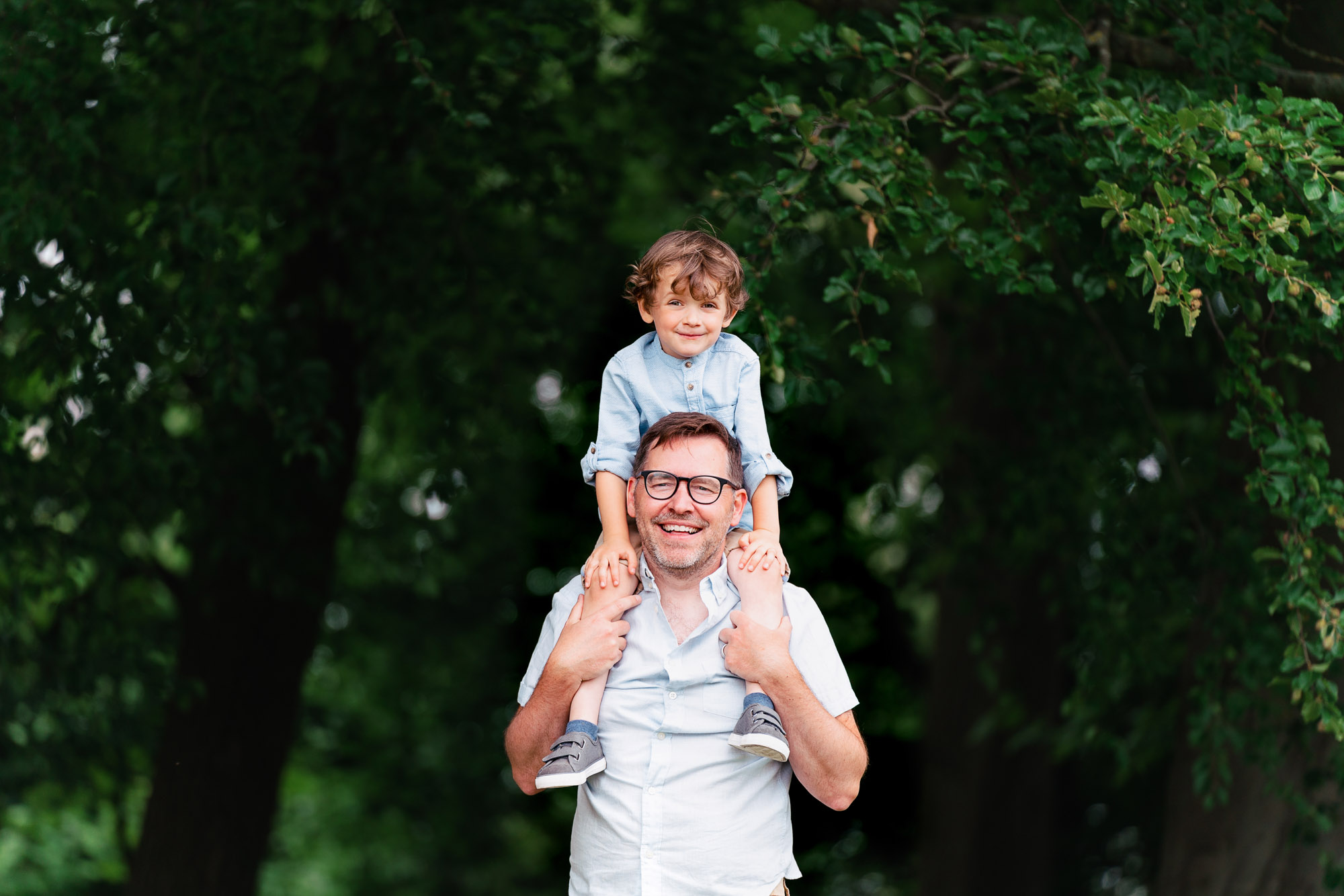 professional family portrait od dad and two sons. All wearing white shirts and denim jeans in front of a grey backdrop. Photograph by Beautiful Bairns photography Edinburgh family photographer