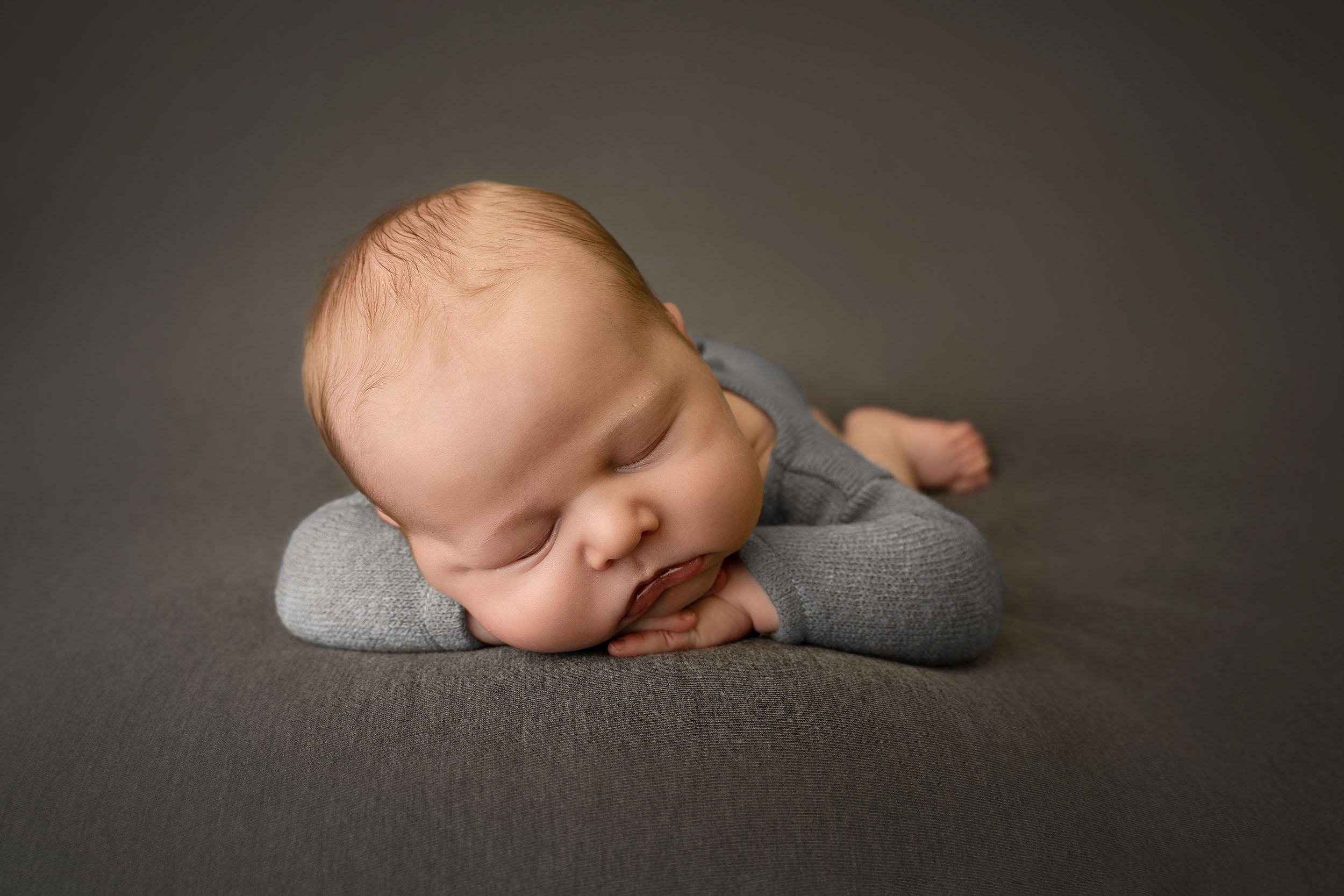 baby posed sleeping on grey fabric by Newborn photographer Edinburgh