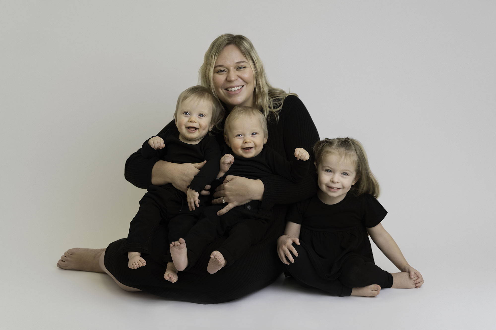 professional family portrait of mum with two sons and daughter all wearing black