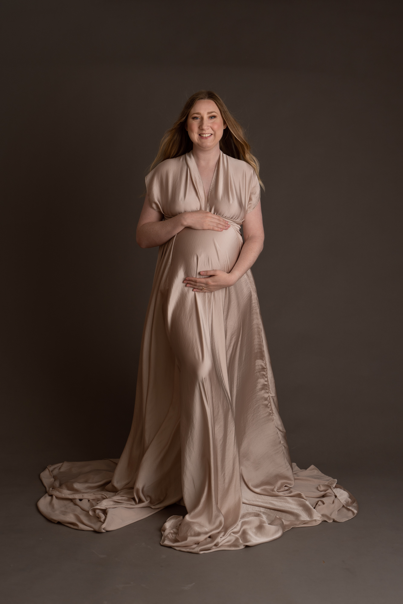 maternity photoshoot image of pregnant woman wearing an elegant silk dress showing off her pregnancy bump by edinburgh maternity photographer beautiful bairns photography