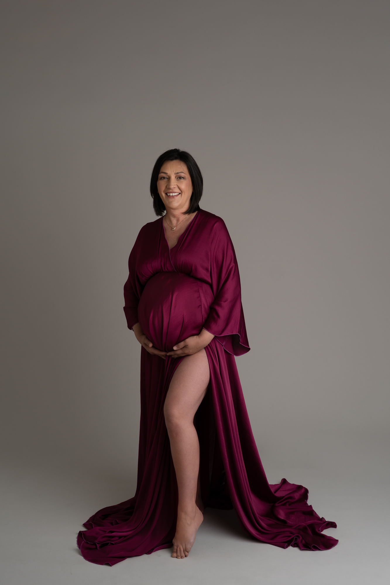 maternity photoshoot image of pregnant woman wearing a plum coloured silk dress by edinburgh maternity photographer beautiful bairns photography
