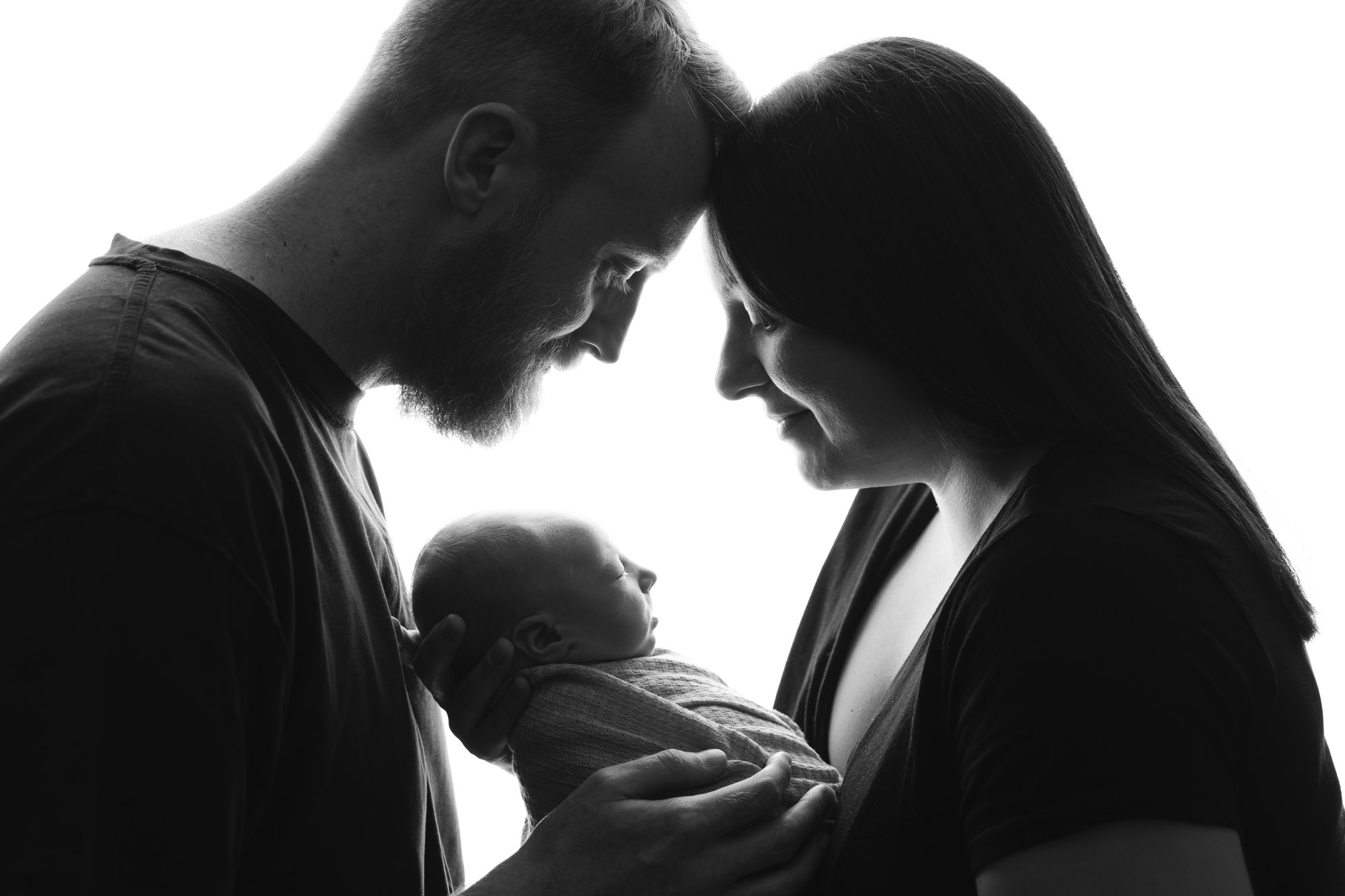 backlit black and white family portrait of parents with baby by newborn photographer edinburgh